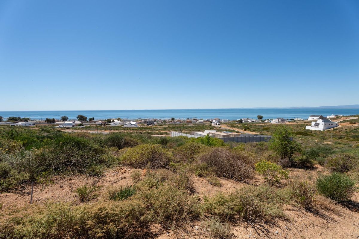 A scenic elevated view overlooking the coastal landscape and ocean, showcasing the natural terrain and surrounding residential area.