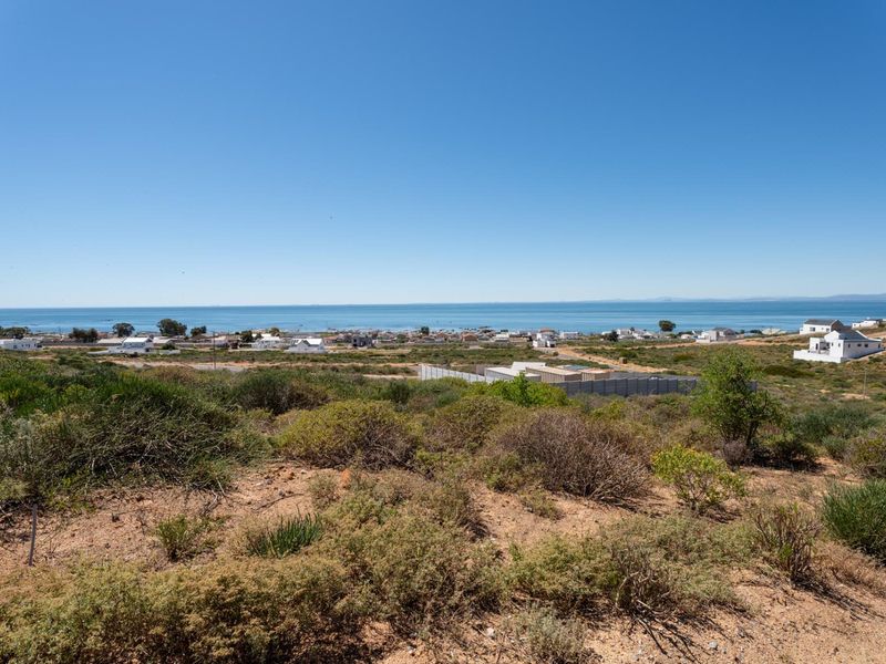 A scenic elevated view overlooking the coastal landscape and ocean, showcasing the natural terrain and surrounding residential area.