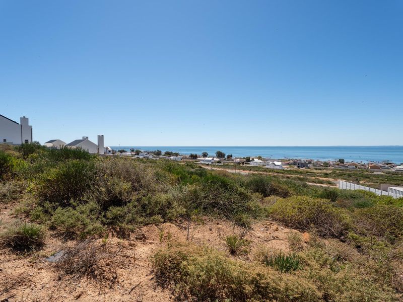 A scenic elevated view overlooking the coastal landscape, surrounding residential properties, and the ocean horizon.