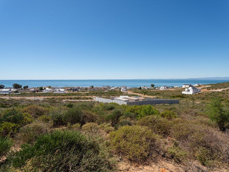 A scenic elevated view overlooking the coastal landscape and ocean, showcasing the surrounding residential area and natural terrain.