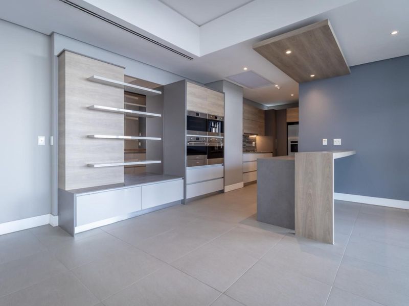 Modern kitchen featuring high-end built-in appliances, sleek cabinetry, a functional island, and recessed lighting in a contemporary open-plan layout.