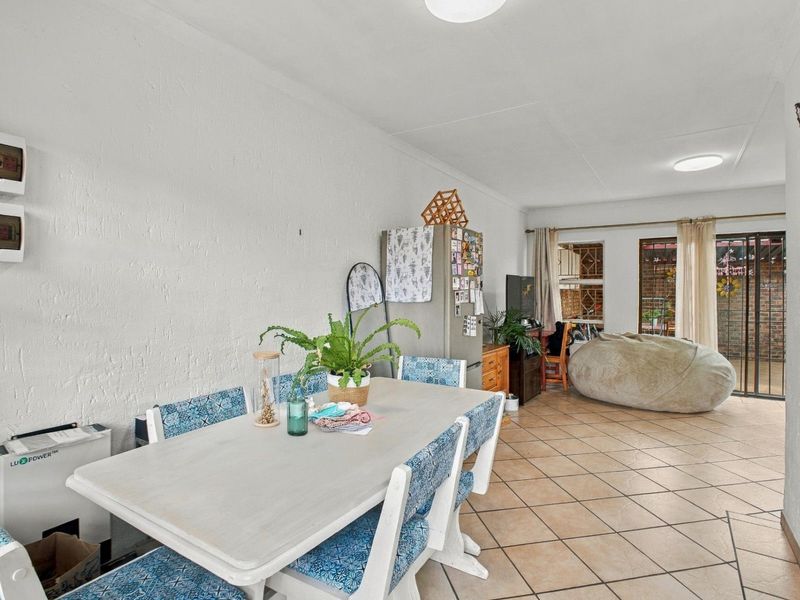 Open plan living and dining area featuring ceramic floor tiles and sliding glass doors leading to an outdoor space.