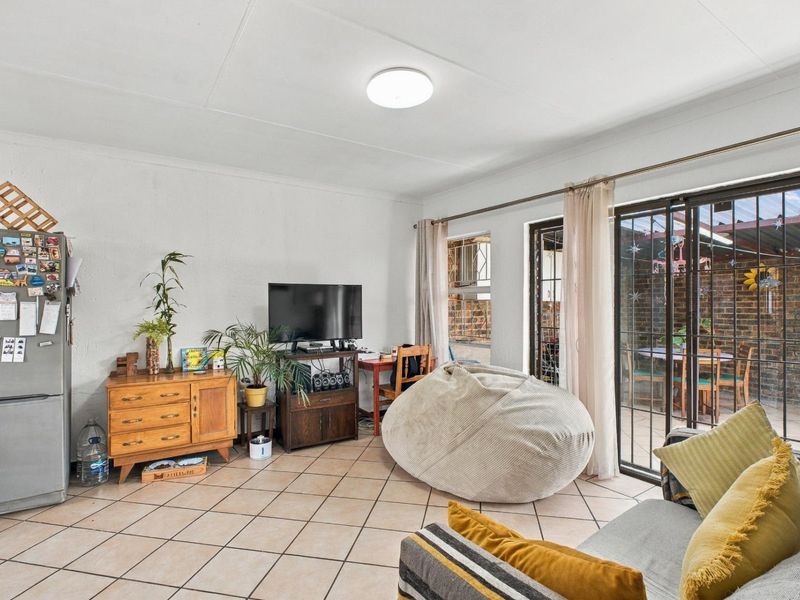 Open plan living area featuring tiled flooring and large sliding glass doors providing access to an outdoor patio space.