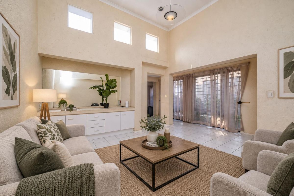 Spacious living room featuring high ceilings, clerestory windows, tiled flooring, and built-in cabinetry with a large integrated mirror.