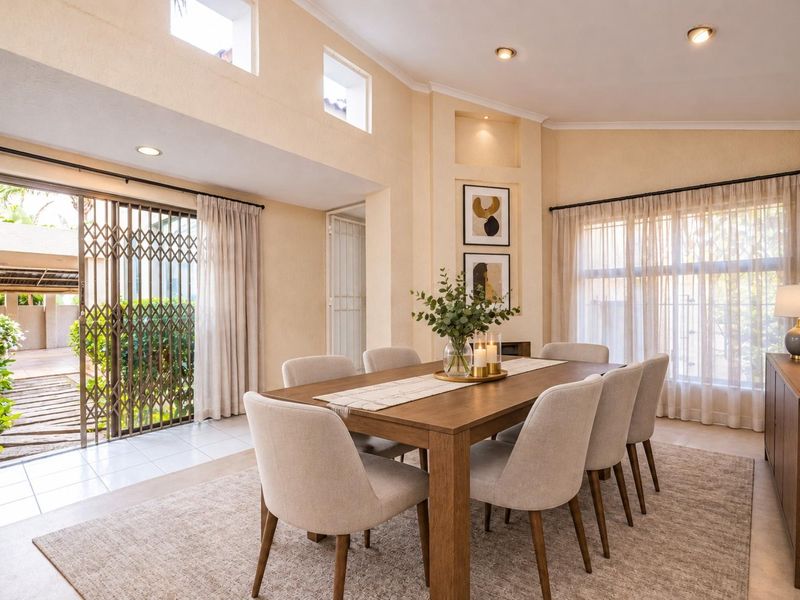 Bright dining room featuring high ceilings, recessed lighting, and a sliding glass door providing direct access to the outdoor patio area.