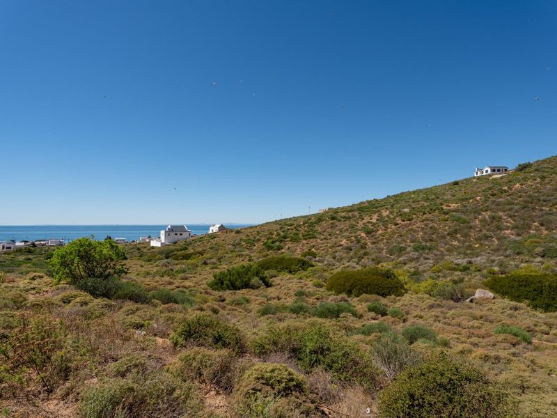 A scenic view of the coastal landscape and sloped terrain, showcasing the natural surroundings of the vacant residential land.
