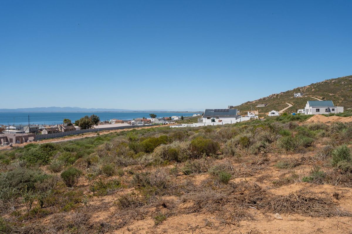 A scenic elevated view overlooking the coastal landscape, surrounding residential properties, and the ocean in the distance.