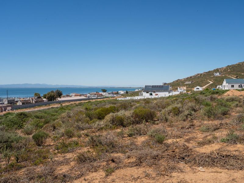 A scenic elevated view overlooking the coastal landscape, surrounding residential properties, and the ocean in the distance.
