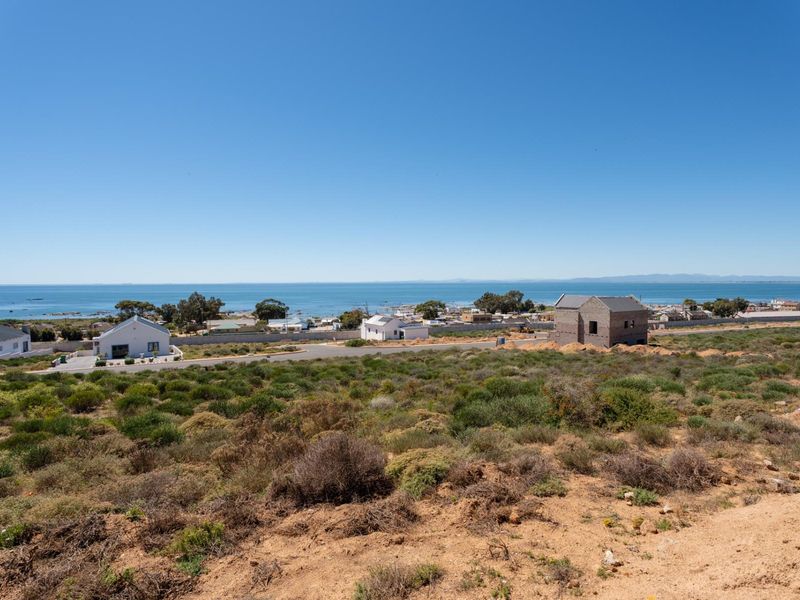 A scenic elevated view overlooking the coastal landscape, surrounding residential properties, and the ocean horizon.