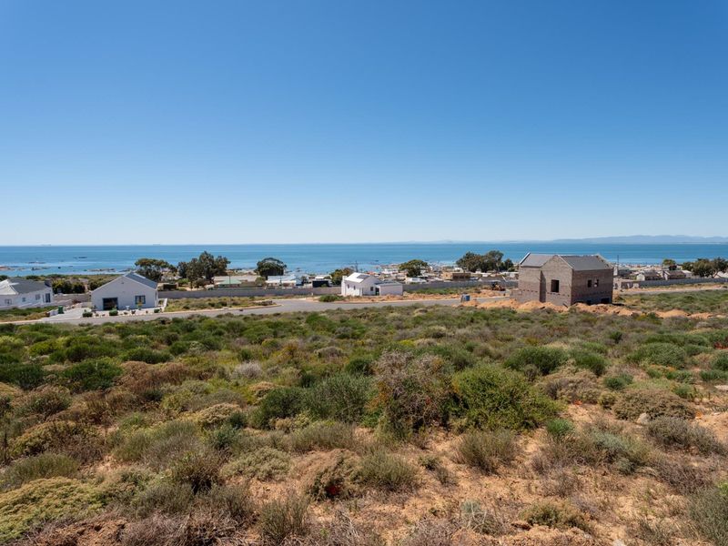 A scenic elevated view overlooking the coastal landscape, surrounding residential properties, and the ocean horizon.