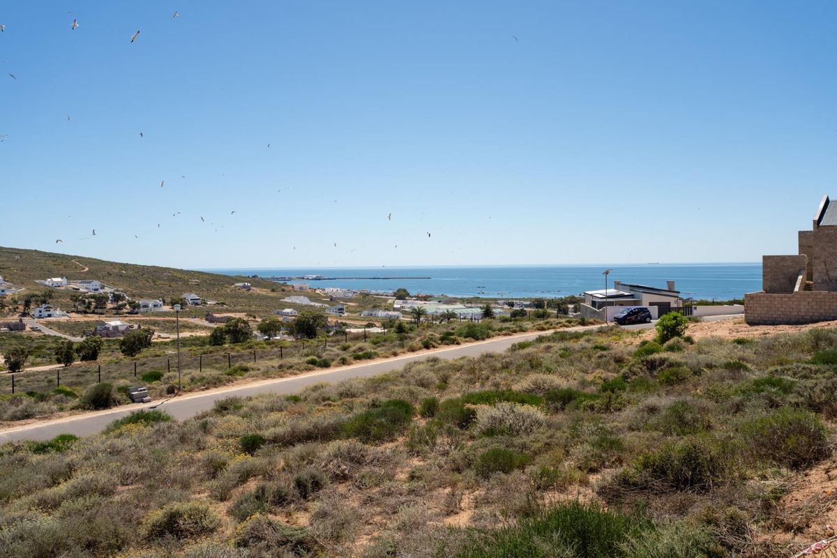 A scenic elevated view overlooking the coastal landscape, surrounding residential properties, and the ocean horizon.