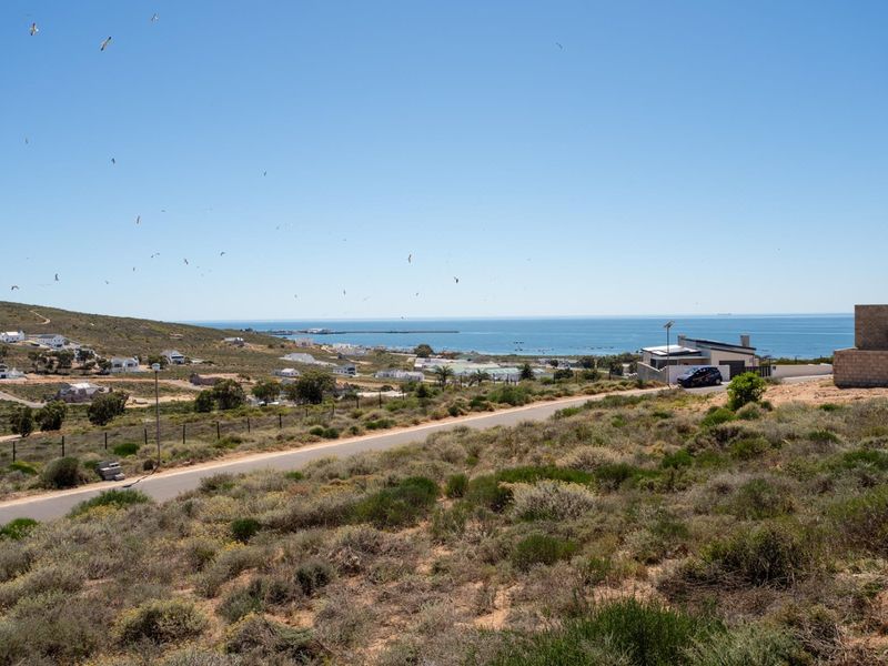 A scenic elevated view overlooking the coastal landscape, surrounding residential properties, and the ocean horizon.
