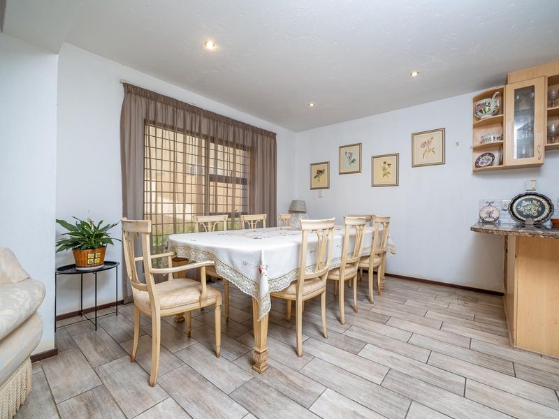A dining area featuring tiled flooring, recessed lighting, and built-in cabinetry with a stone countertop, providing a functional space for meals.