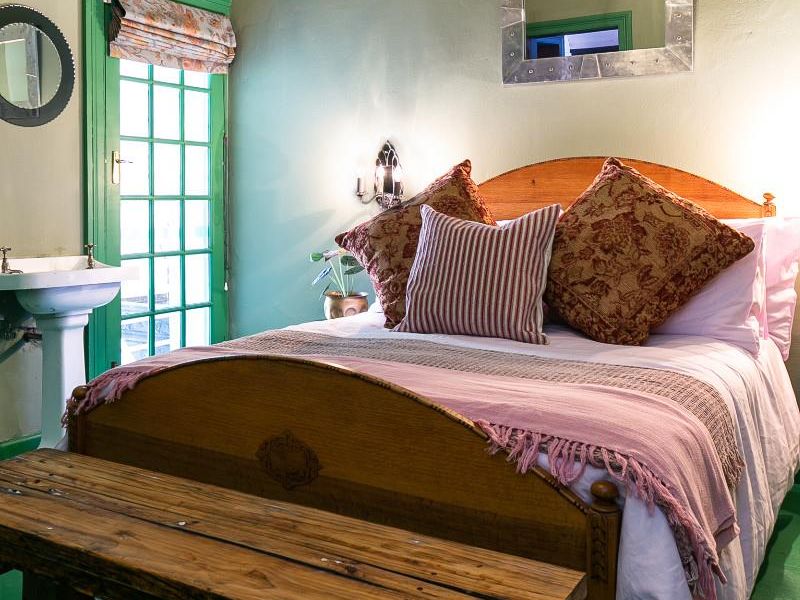 A bedroom featuring a pedestal wash basin, wall-mounted air conditioning, and a multi-pane glass door leading to an outdoor area.