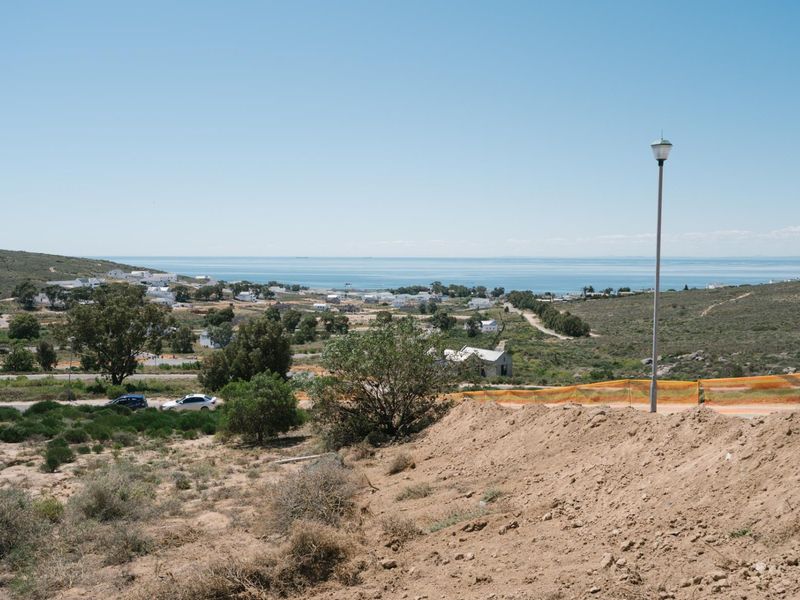 A scenic elevated view overlooking the surrounding coastal landscape and residential area, featuring natural terrain and a clear horizon line.