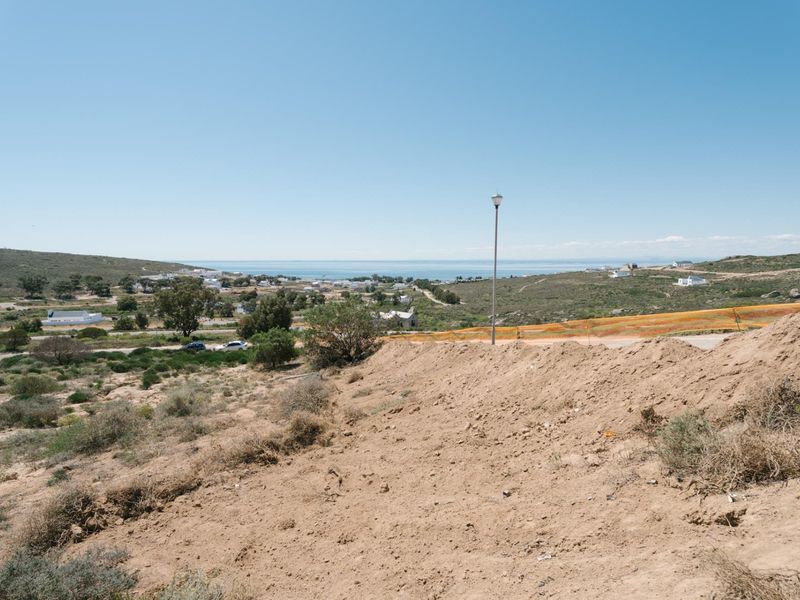 A wide-angle view overlooking the vacant residential land with distant coastal and landscape scenery.
