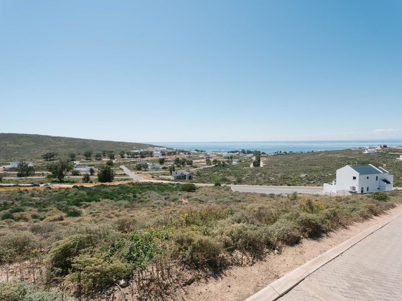 A scenic elevated view overlooking the coastal landscape, surrounding residential area, and distant ocean horizon.