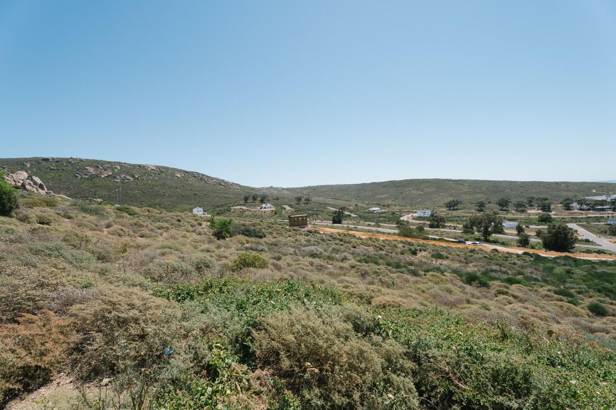 A wide-angle view of the vacant residential land, showcasing the natural sloped terrain and surrounding landscape.