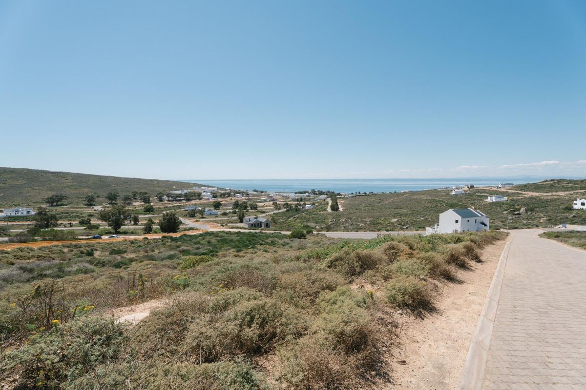Elevated view overlooking the surrounding coastal landscape and residential area, featuring a paved access road in the foreground.
