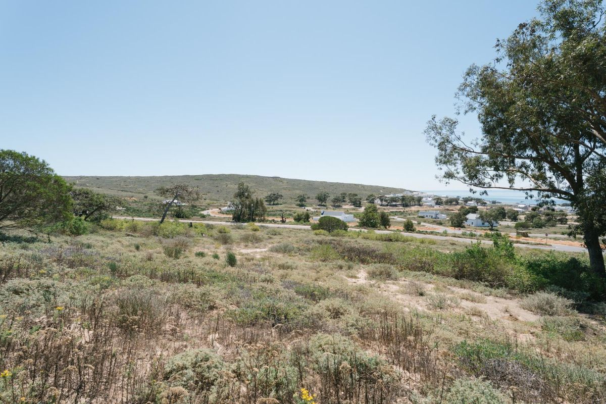 A scenic view of the surrounding coastal landscape and natural vegetation, showcasing the open terrain of the vacant residential land.