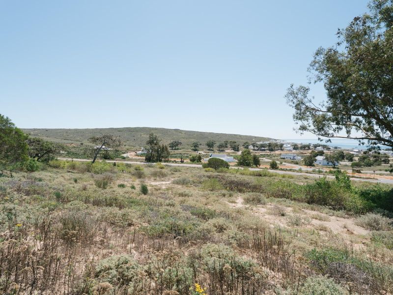 A scenic view of the surrounding coastal landscape and natural vegetation, showcasing the open terrain of the vacant residential land.