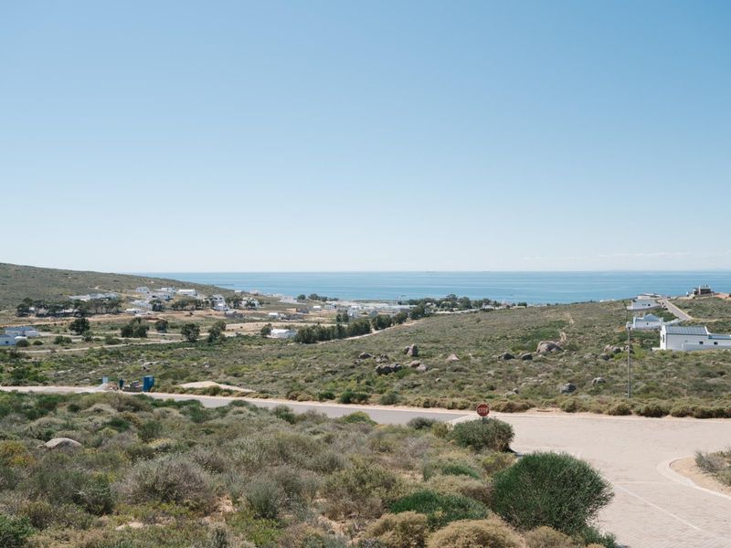 An elevated view of the coastal landscape and surrounding residential area, showcasing the property's scenic location and proximity to the ocean.