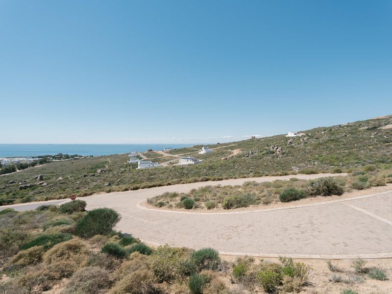 A scenic elevated view of the coastal landscape featuring a paved road and surrounding natural terrain.