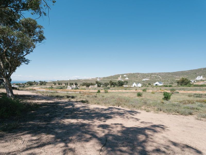 A wide-angle view of the vacant residential land, showcasing the natural landscape and surrounding neighborhood terrain.