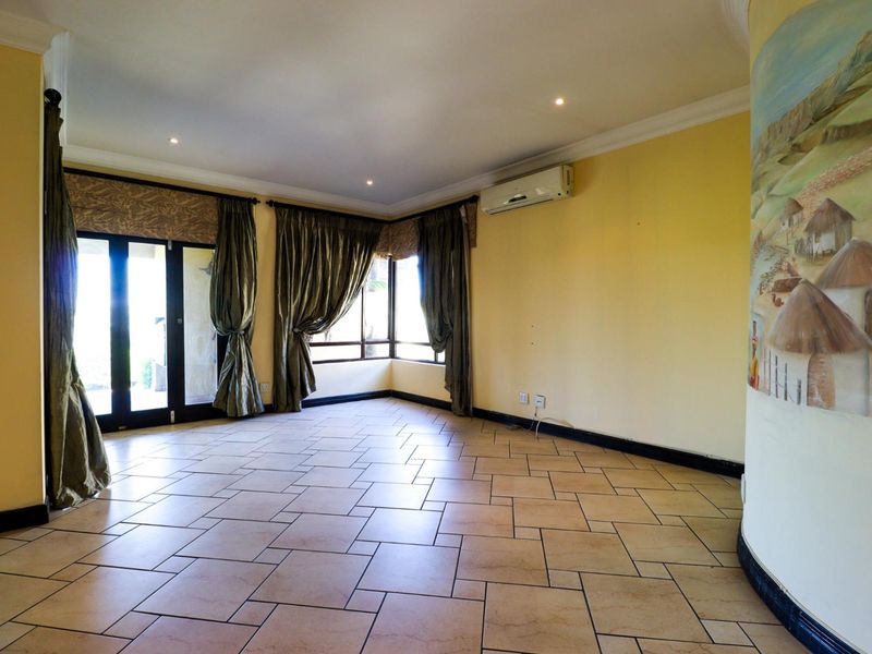 Spacious living area featuring tiled flooring, recessed lighting, a split-system air conditioner, and large sliding glass doors leading to the exterior.
