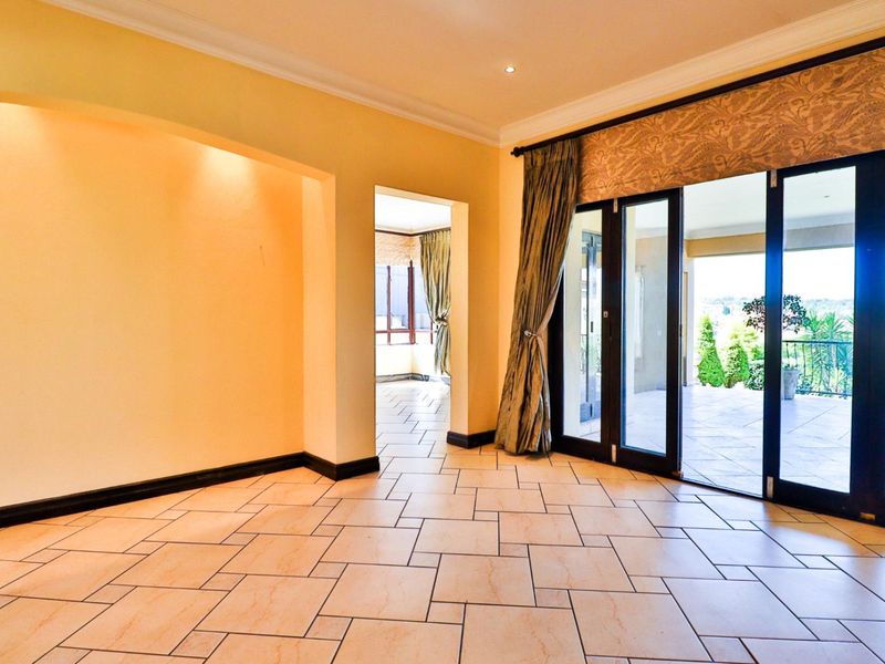 Spacious living area featuring tiled flooring, recessed lighting, and large sliding glass doors providing seamless access to the outdoor patio.