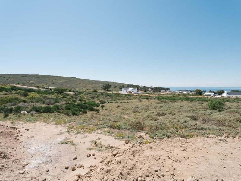 A wide-angle view of the vacant residential land, showcasing the natural coastal landscape and surrounding area.