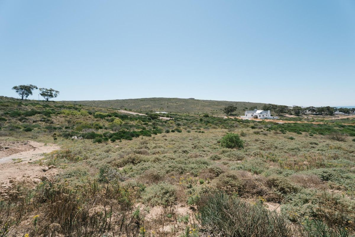 A wide-angle view of the vacant residential land featuring natural coastal vegetation and surrounding landscape.