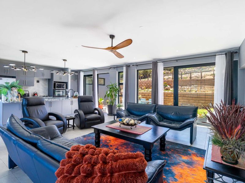 Spacious open-plan living area featuring a modern kitchen with built-in cabinetry, an island, and large sliding doors providing seamless access to the rear garden.