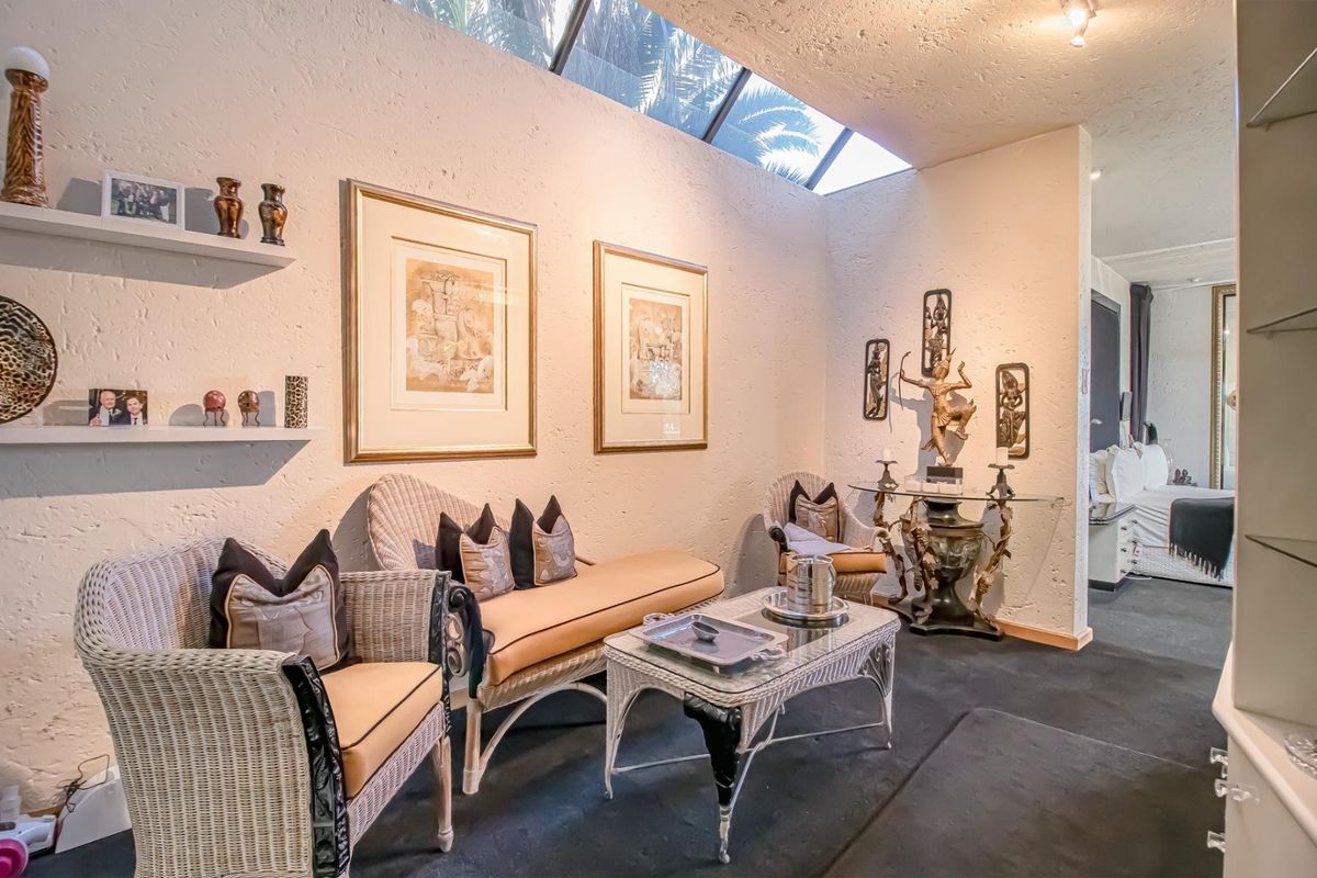 A cozy living area featuring textured walls, a large overhead skylight providing natural light, and built-in wall shelving.