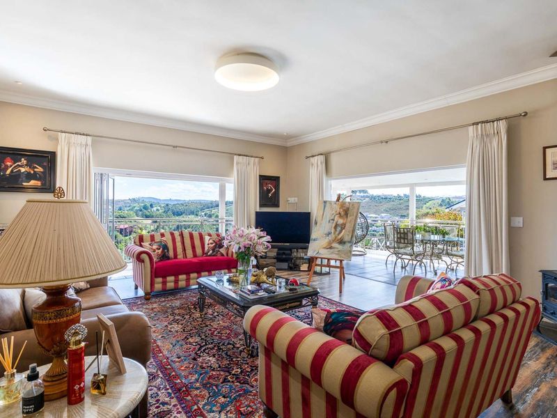 Spacious living room featuring a wood-burning stove, large sliding glass doors opening to a balcony, and views of the surrounding landscape.