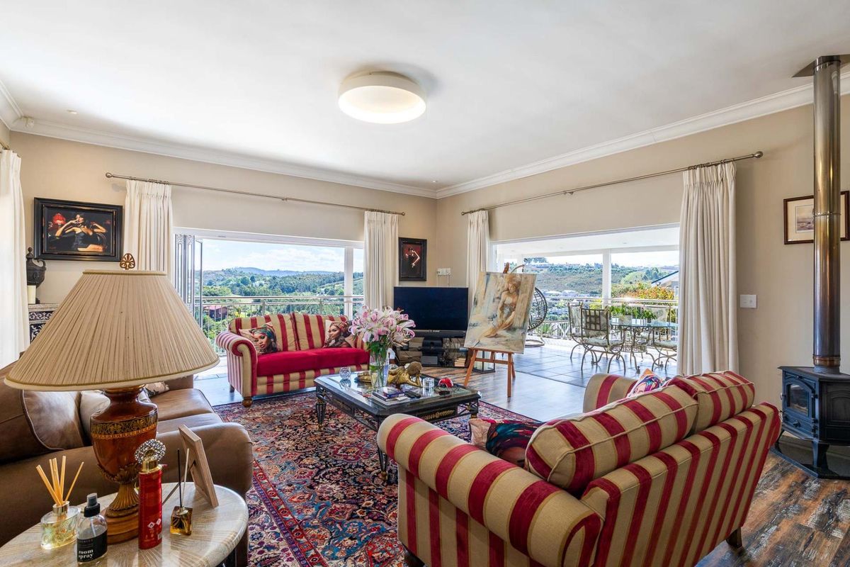 Spacious living room featuring a wood-burning stove, large sliding glass doors opening to a balcony, and views of the surrounding landscape.