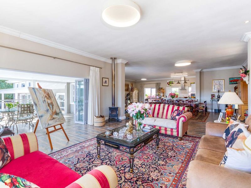 Spacious open-plan living area featuring a wood-burning stove, tiled flooring, and seamless flow to an outdoor patio through large bi-fold doors.