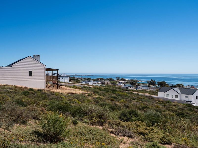 A scenic elevated view overlooking the coastal landscape, surrounding residential properties, and the ocean horizon.