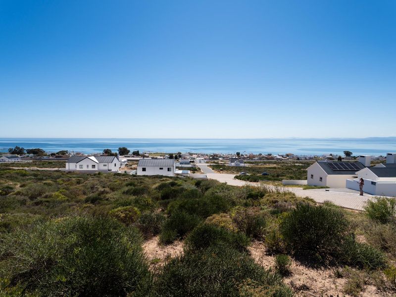 A scenic elevated view overlooking the coastal landscape and ocean, showcasing the surrounding residential neighborhood and natural terrain.