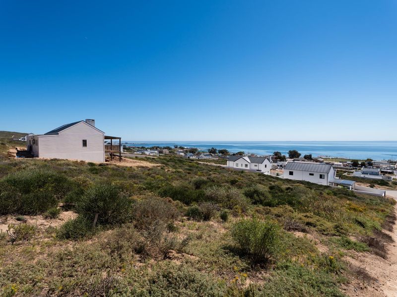 A scenic elevated view overlooking the coastal landscape, surrounding residential properties, and the ocean horizon.
