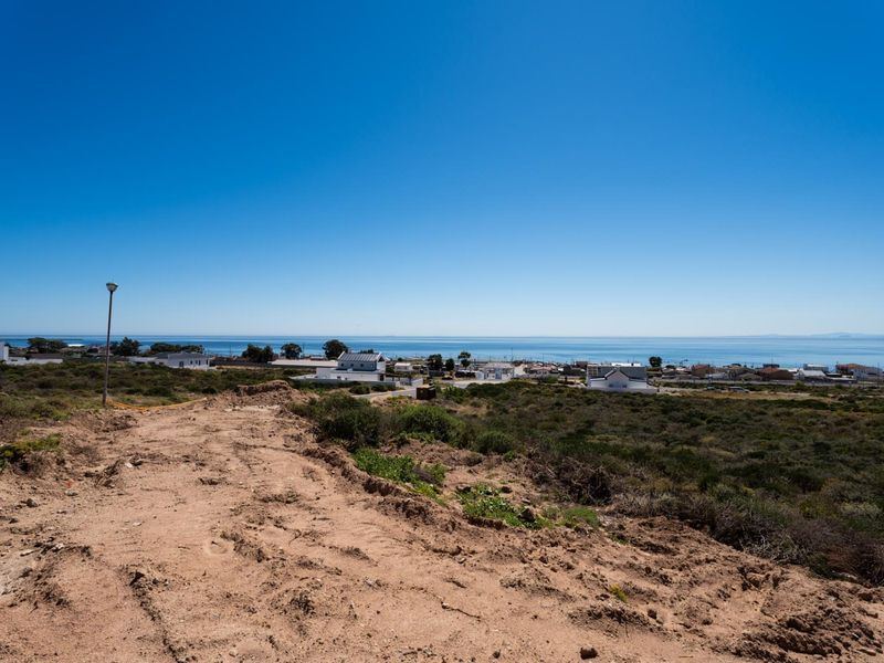 A wide-angle view of the vacant residential land overlooking the coastal town and ocean horizon.