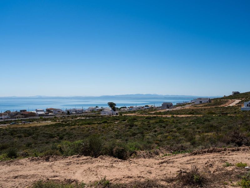 A scenic elevated view overlooking the coastal landscape and ocean, showcasing the surrounding residential area and natural terrain.