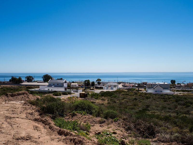 A scenic elevated view overlooking the coastal landscape and ocean, showcasing the surrounding residential area and natural terrain.