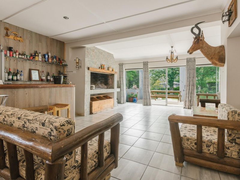 Spacious entertainment area featuring a built-in bar, stone fireplace, and large sliding doors opening to an outdoor patio.
