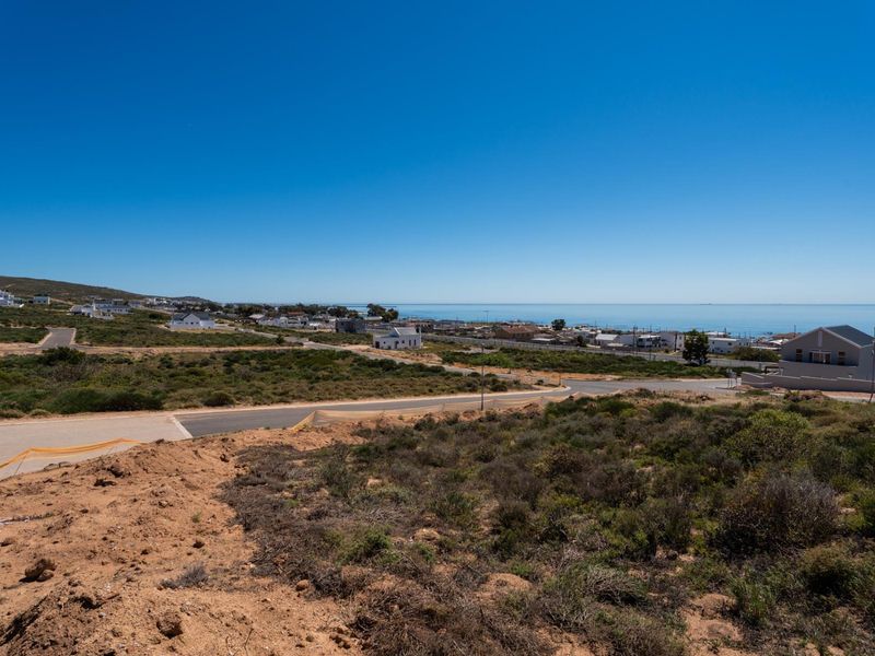 An elevated view overlooking the vacant residential land, surrounding coastal neighborhood, and the ocean horizon.