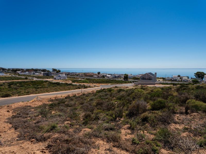 Elevated view of the surrounding coastal landscape and residential neighborhood, showcasing the property's proximity to the ocean and local infrastructure.