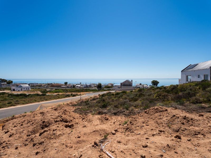 A wide-angle view overlooking the vacant residential land towards the coastal landscape and surrounding neighborhood.