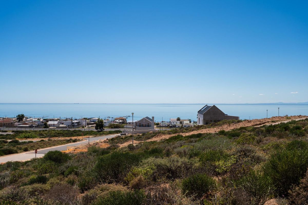 A scenic elevated view overlooking the coastal landscape, nearby residential properties, and the ocean horizon.