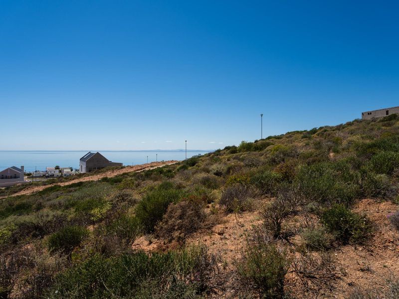 A scenic view of the sloped residential land overlooking the coastline and surrounding neighborhood.