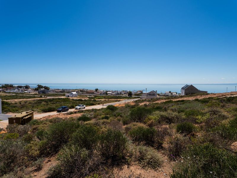 A scenic elevated view overlooking the coastal landscape and ocean, showcasing the surrounding residential area and natural terrain.